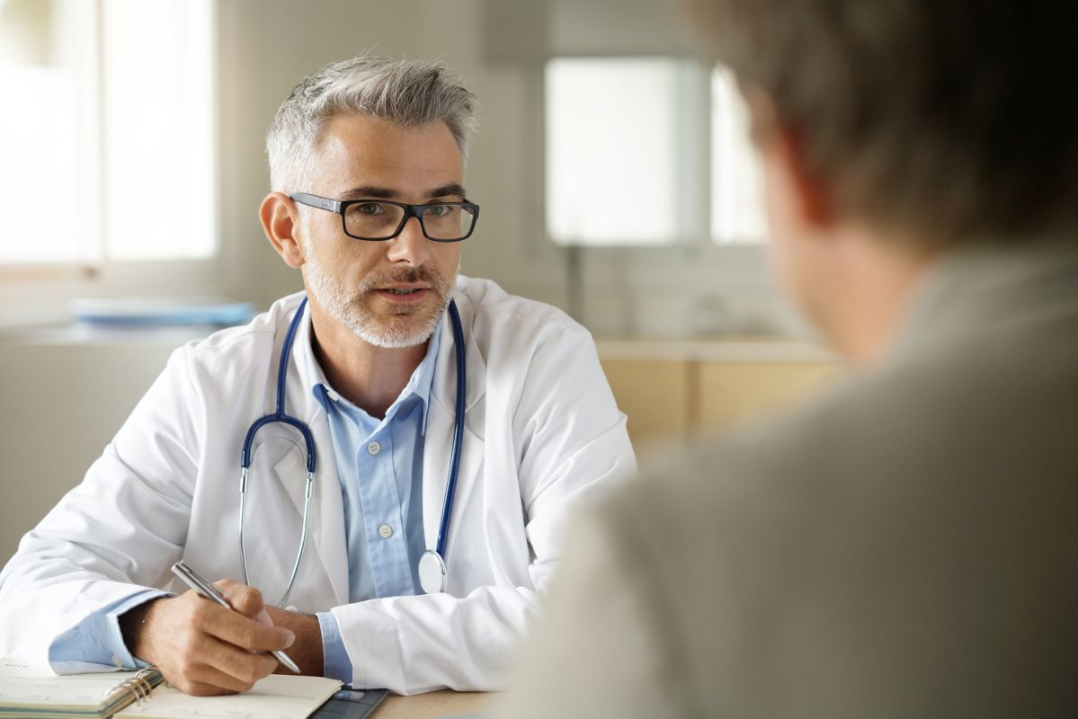 Ein Arzt spricht mit einem Patienten in der Sprechstunde